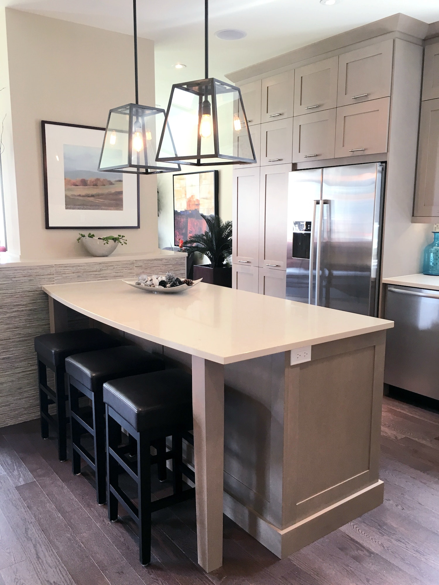 Modern kitchen with gleaming quartz countertop fancy light fixtures and neutral cupboards, design